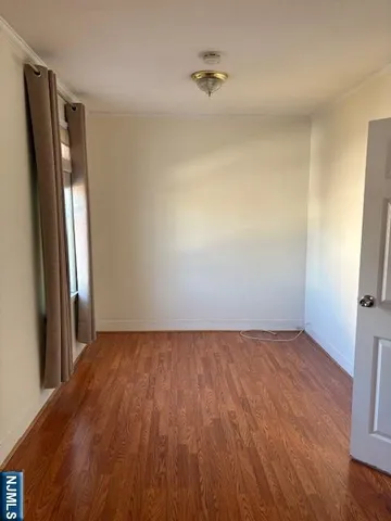 an empty room with wooden floor and a window