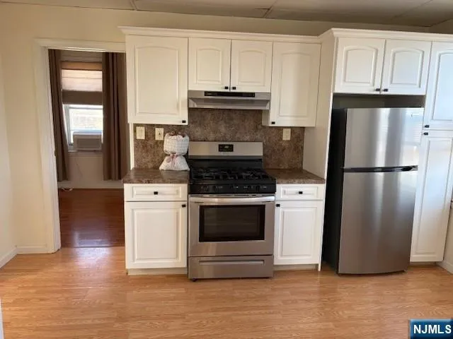 a kitchen with granite countertop a refrigerator and a stove