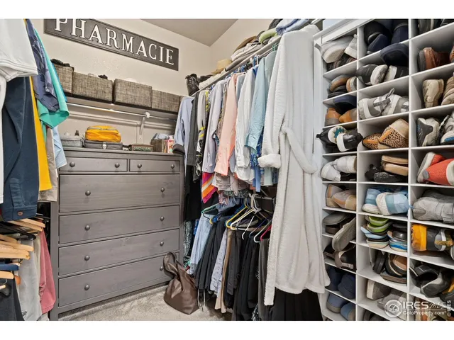 a view of walk in closet with clothes and shoes