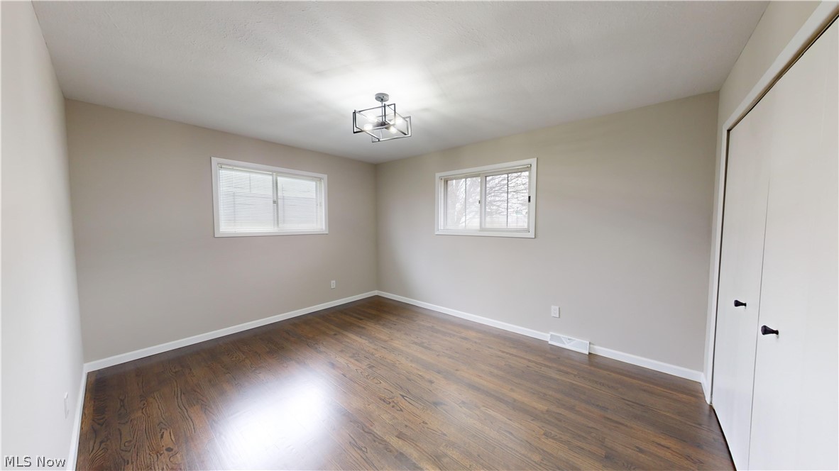 1224 Cordova Road Mayfield Heights, OH 44124 - Photo 18 of 29 Unfurnished bedroom featuring dark hardwood / wood-style floors, multiple windows, and a closet