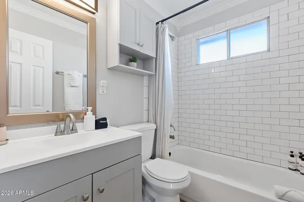 a bathroom with a toilet sink vanity and mirror