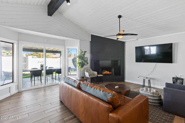 a living room with furniture a flat screen tv and a fireplace