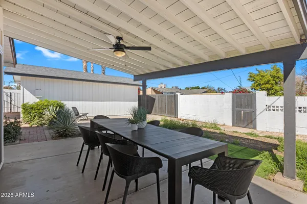 a view of a backyard with table and chairs potted plants