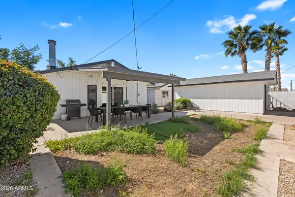 a view of a house with backyard and sitting area