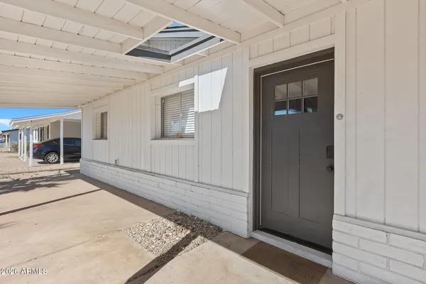 a view of a dining room and livingroom with furniture a rug and a clock