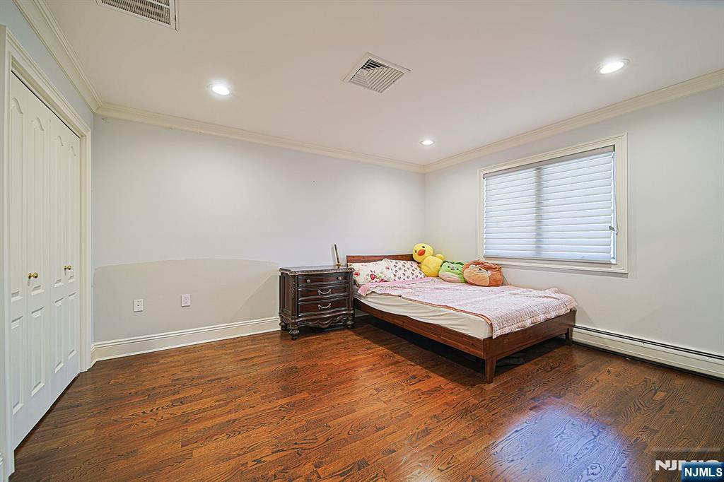 897 Virgil Avenue Ridgefield, NJ 07657 - Photo 42 of 50 a bedroom with wooden floor and a window