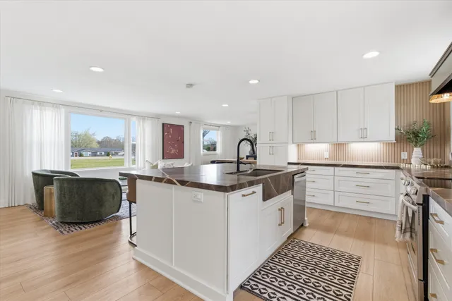 a kitchen with stainless steel appliances granite countertop a stove a sink and a refrigerator