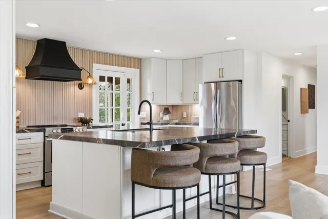 a kitchen with stainless steel appliances a sink a stove a refrigerator and cabinets