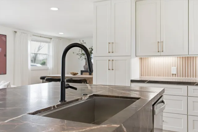 a kitchen with granite countertop a sink and a stove top oven with wooden floor