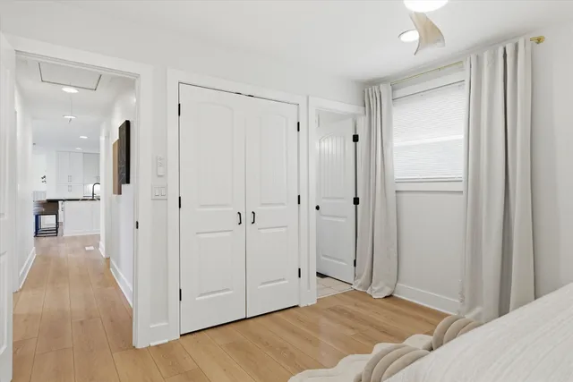 a view of a bedroom with a bed and wooden floor
