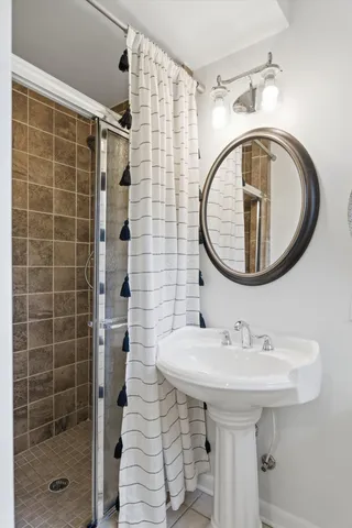 a bathroom with a sink a mirror and shower