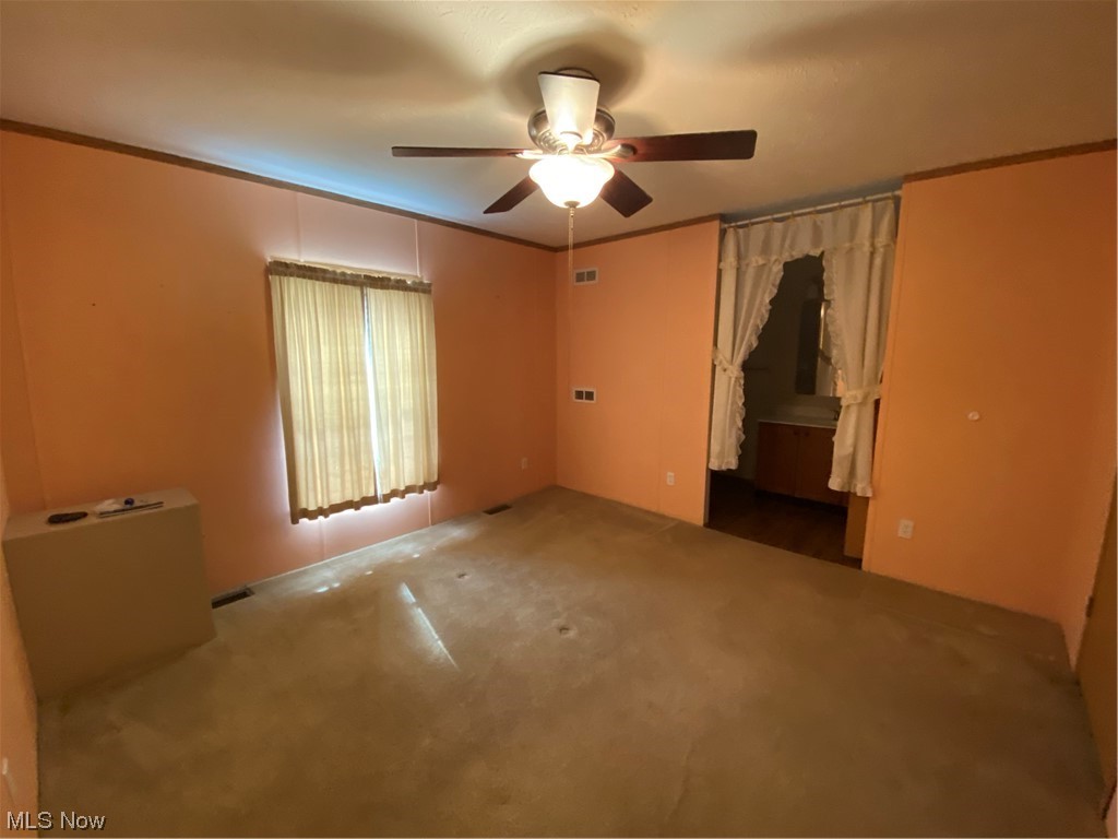 85 Rains Circle Zanesville, OH 43701 - Photo 12 of 15 Carpeted spare room featuring ornamental molding and ceiling fan
