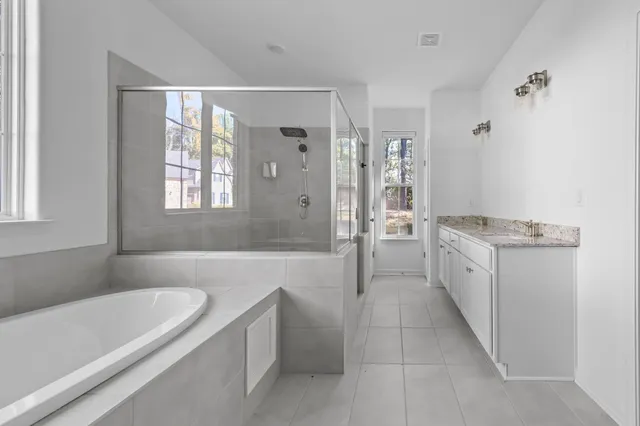 a bathroom with a granite countertop tub sink shower and mirror