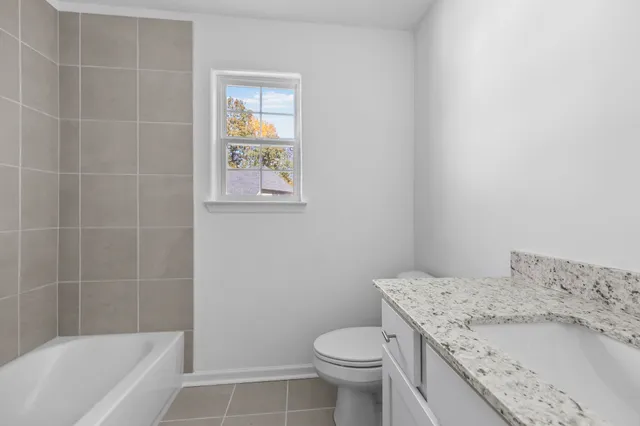 a bathroom with a granite countertop toilet a sink and bathtub