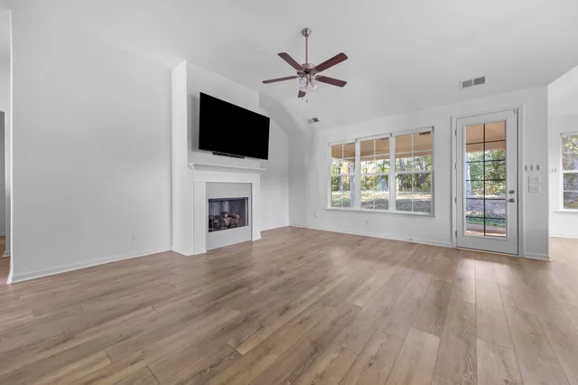 a view of a livingroom with a flat screen tv wooden floor and a ceiling fan