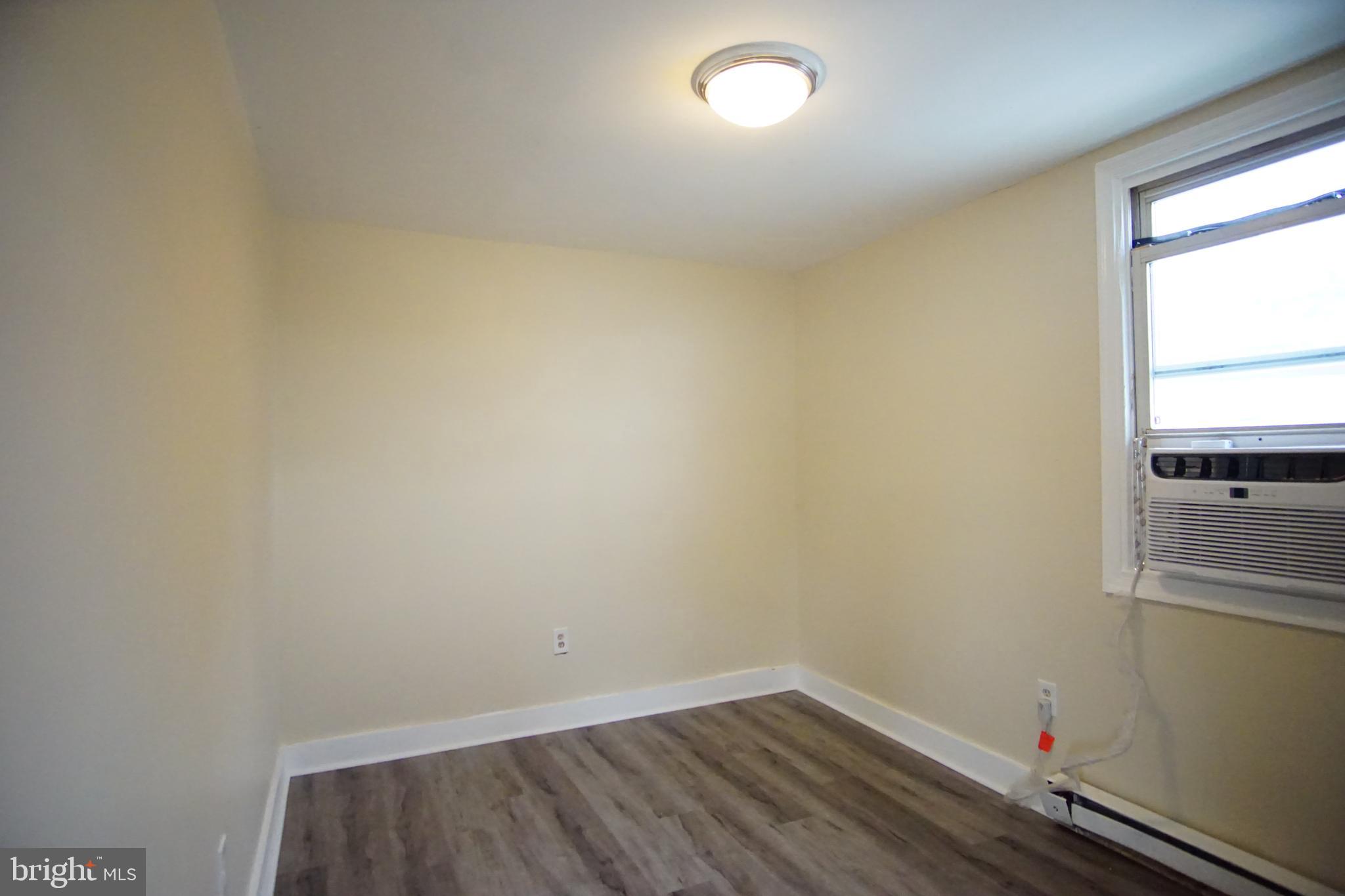 5200 Ballman Avenue, Unit 3 Baltimore, MD 21225 - Photo 13 of 17 a view of a room with wooden floor and small window