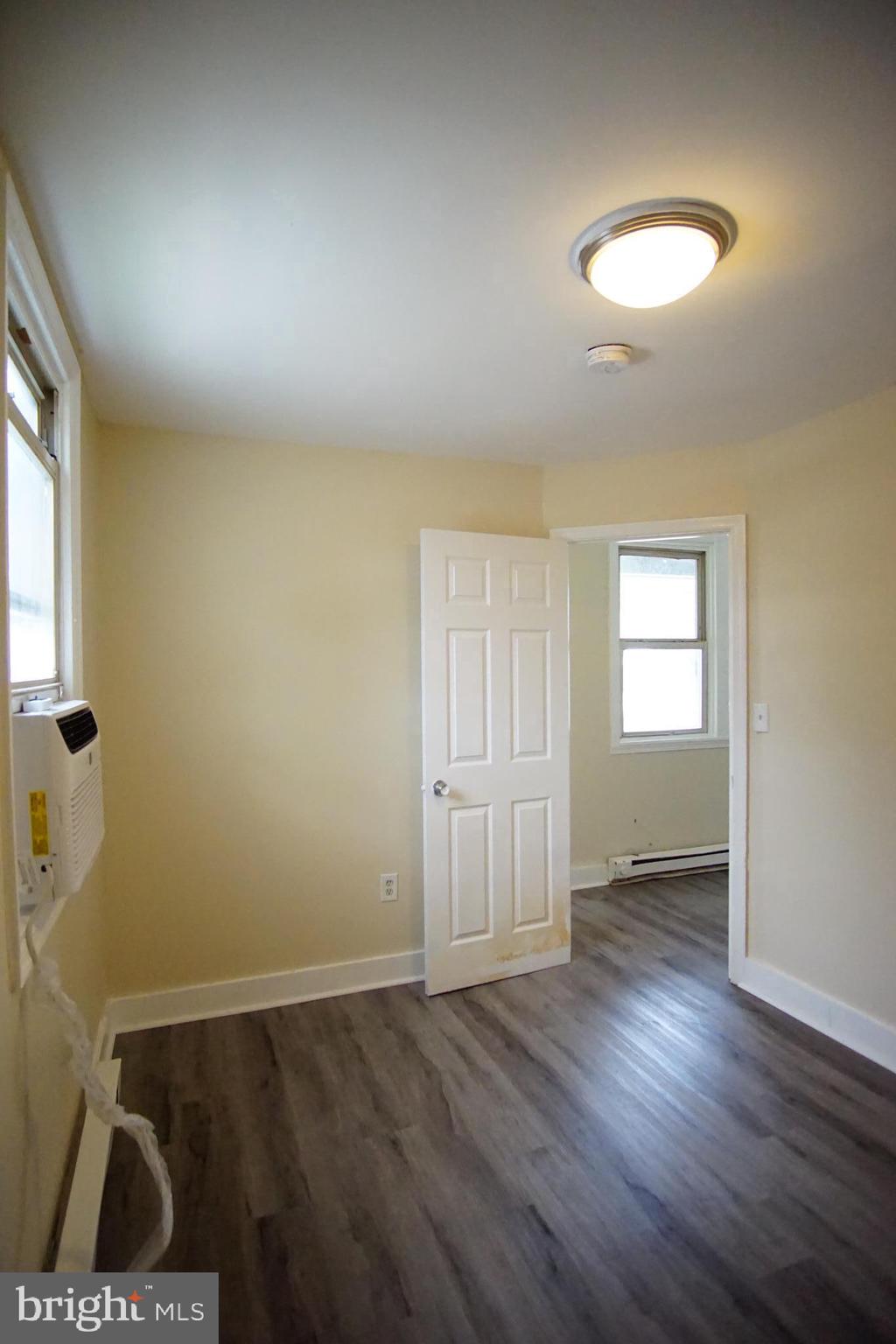 5200 Ballman Avenue, Unit 3 Baltimore, MD 21225 - Photo 16 of 17 an empty room with wooden floor and windows