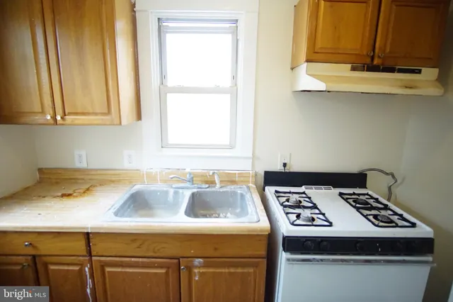 a kitchen with a sink a stove and a microwave