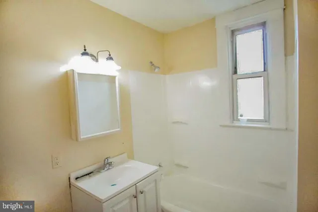 a bathroom with a sink mirror and vanity