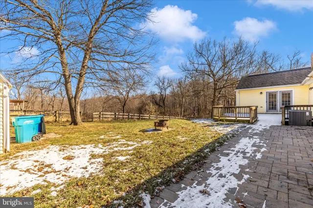 a view of swimming pool with outdoor seating and trees in the background