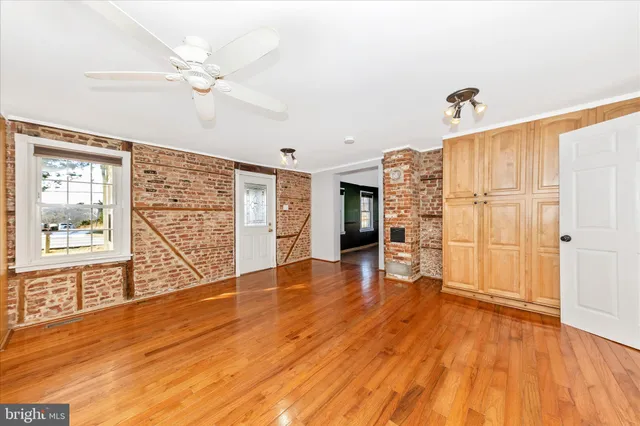 a view of a livingroom with wooden floor and a ceiling fan