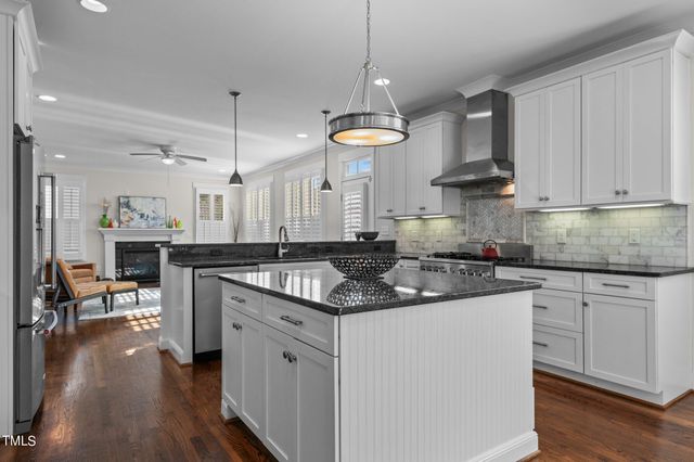 a kitchen with granite countertop a sink a counter space appliances and cabinets