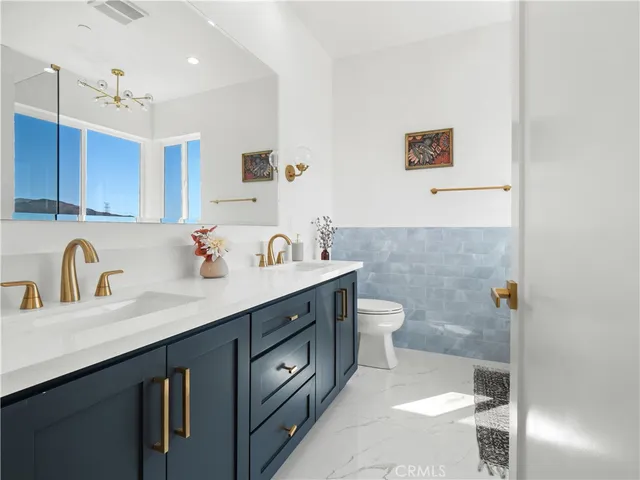 a bathroom with a double vanity sink mirror and toilet