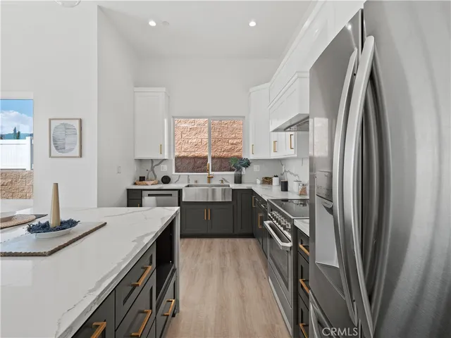 a kitchen with stainless steel appliances a sink stove refrigerator and a window