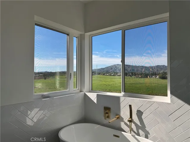 a bathroom with a toilet sink and large window