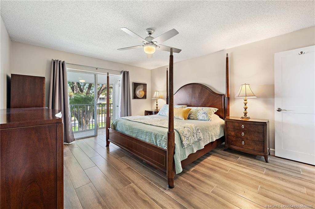 1862 Southwest Palm City Road, Unit 203 Stuart, FL 34994 - Photo 23 of 39 a bedroom with a bed and wooden floor