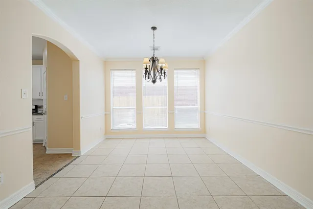 an empty room with chandelier and windows