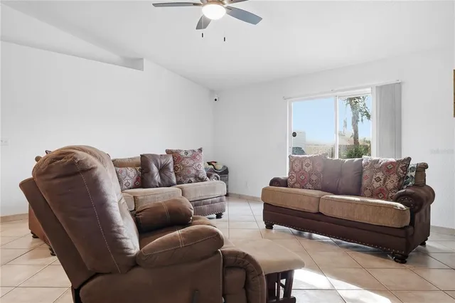 a living room with a couch and a chandelier fan