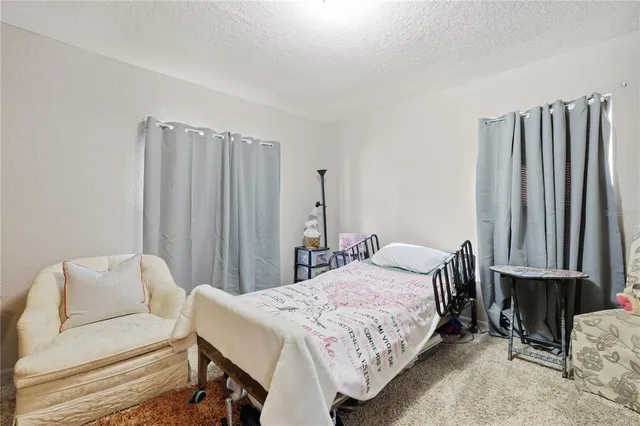 a bedroom with a bed table and chair