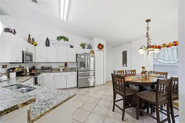 a kitchen with a dining table chairs and white appliances