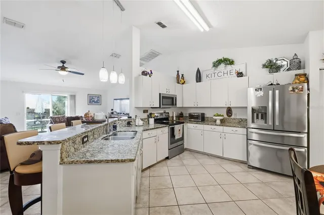 a kitchen with stainless steel appliances granite countertop a sink and a refrigerator