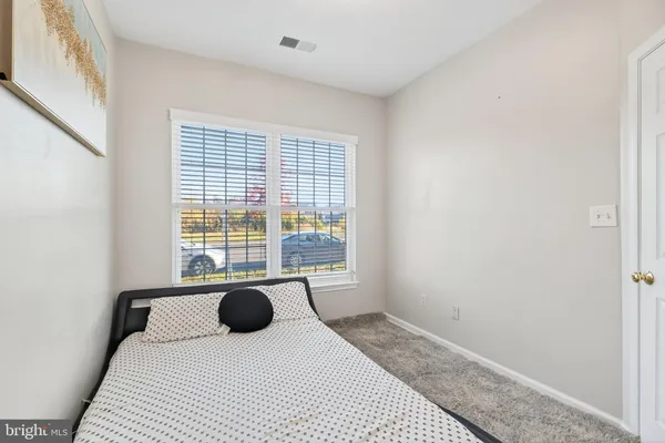 a bedroom with a bed and painting on the wall