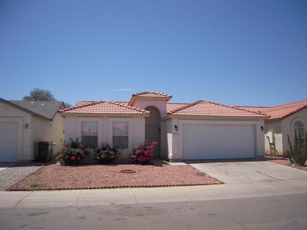 8423 West Almeria Road Phoenix, AZ 85037 - Photo 1 of 3 a front view of a house with a yard and a garage
