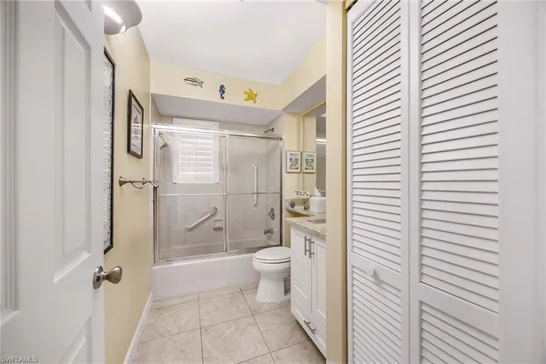 a bathroom with a granite countertop sink a toilet and shower