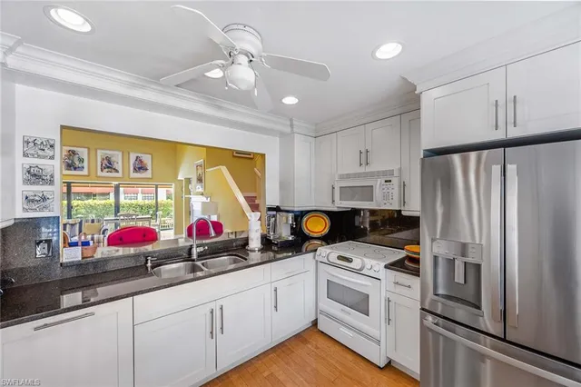 a kitchen that has a lot of cabinets and stainless steel appliances