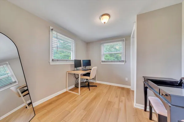 a view of a hallway with wooden floor and closet