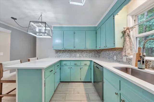 a sink with a window and cabinets