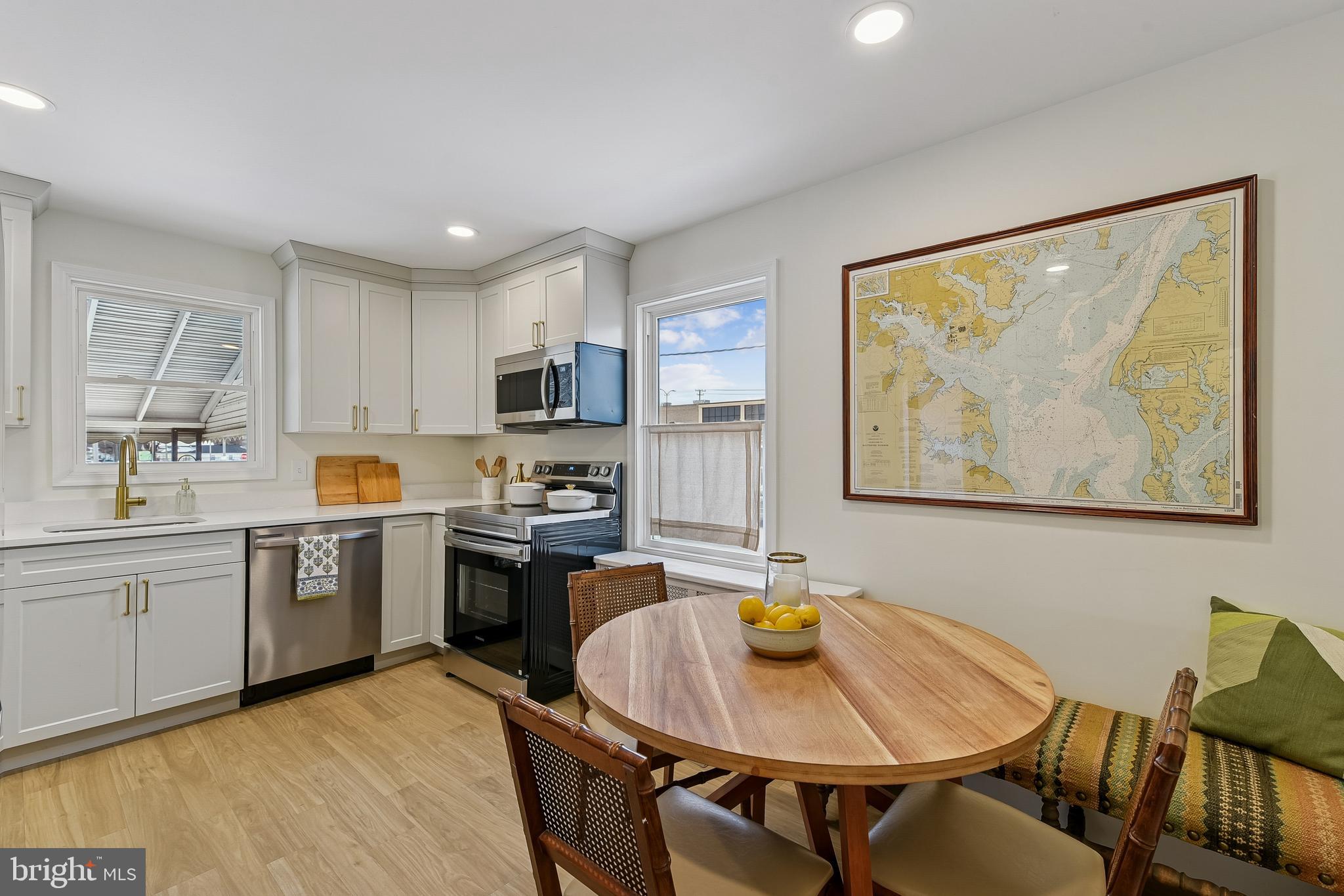 100 Margaret Avenue Baltimore, MD 21221 - Photo 7 of 44 a large kitchen with kitchen island a dining table and stainless steel appliances