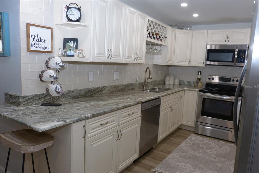 2700 Bayshore Boulevard, Unit 11105 Dunedin, FL 34698 - Photo 11 of 33 a kitchen with stainless steel appliances granite countertop a sink and cabinets