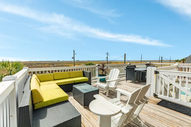 a roof deck with couches and wooden floor