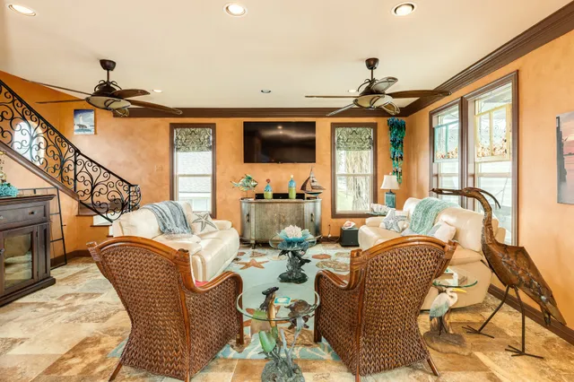 a living room with furniture a flat screen tv and a floor to ceiling window