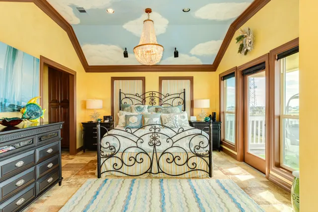 a bedroom with a bed and a large window with the potted plants