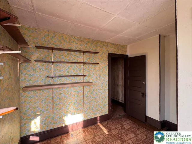 a view of a hallway with furniture and a window