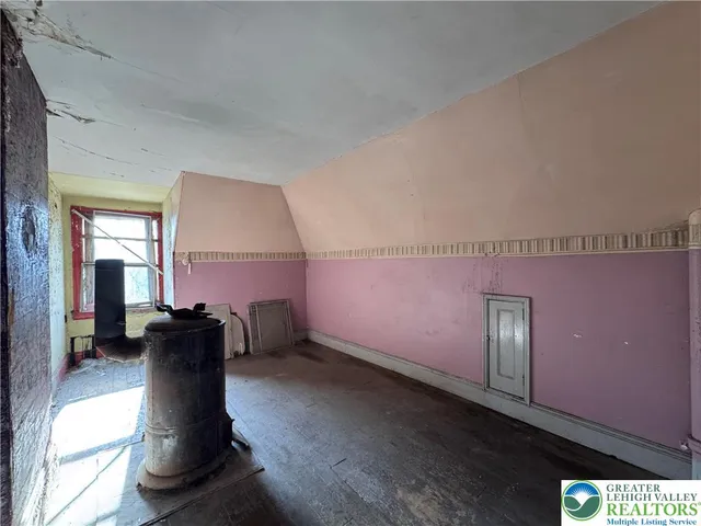 a view of a white house with a large tree