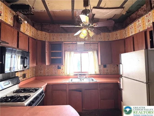 a kitchen with stainless steel appliances a refrigerator a sink a stove and a microwave