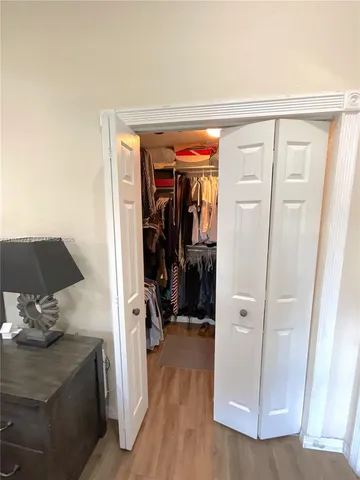a view of walk in closet with clothes and shoes